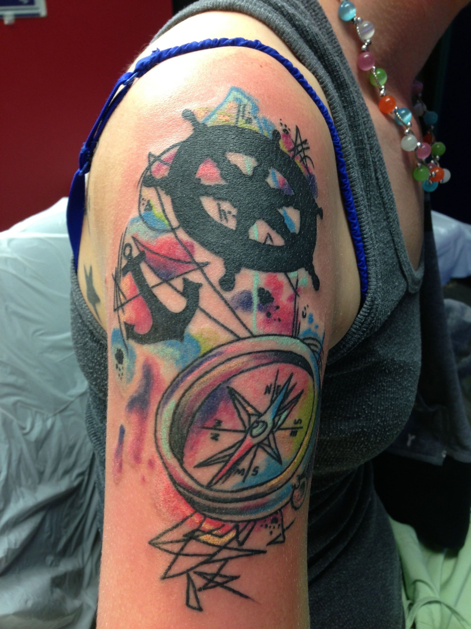 Tatuagem no braço com vários objetos marítimos