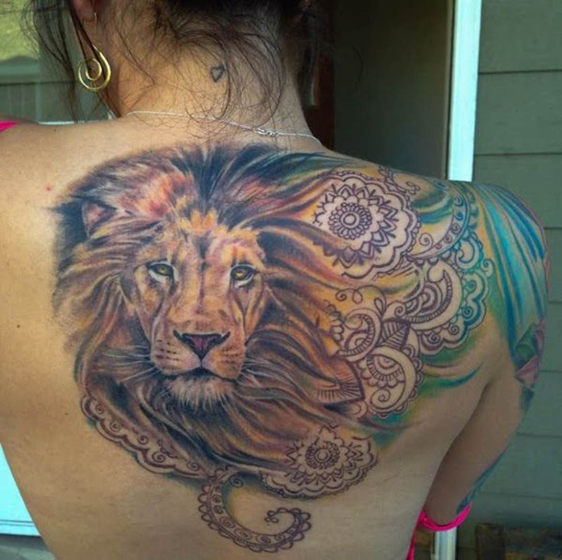 Tatuagem feminina de um leão nas costas