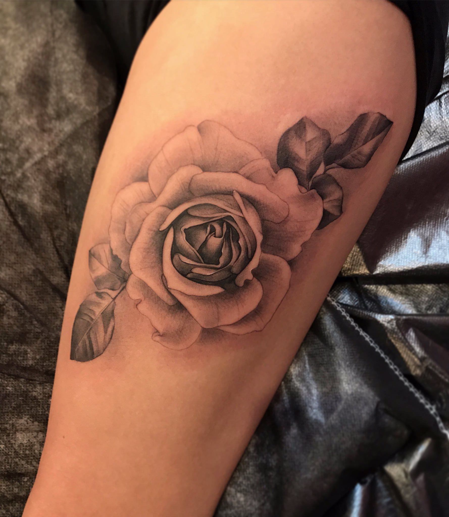 Tattoo no braço de uma rosa em escalas de cinza