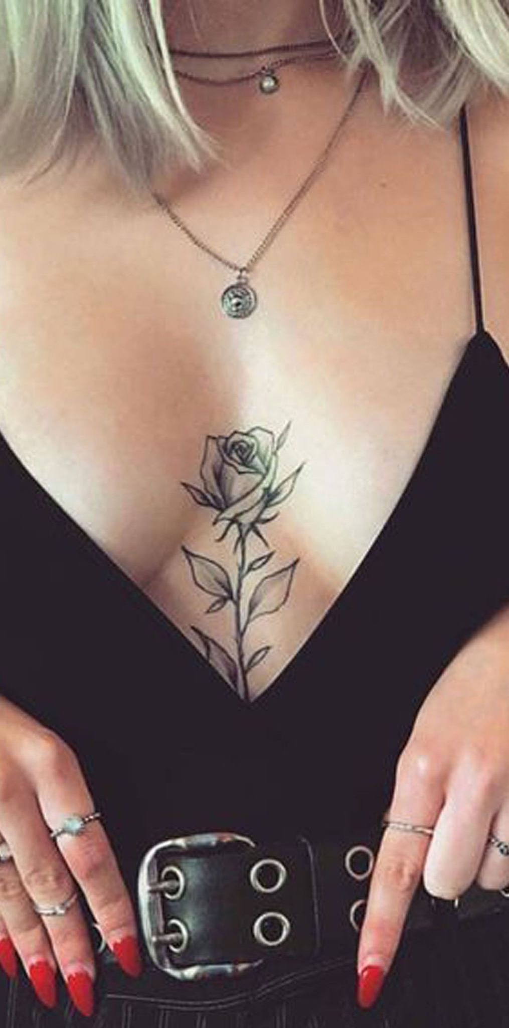 Tatuagem delicada de uma rosa entre os seios (busto)