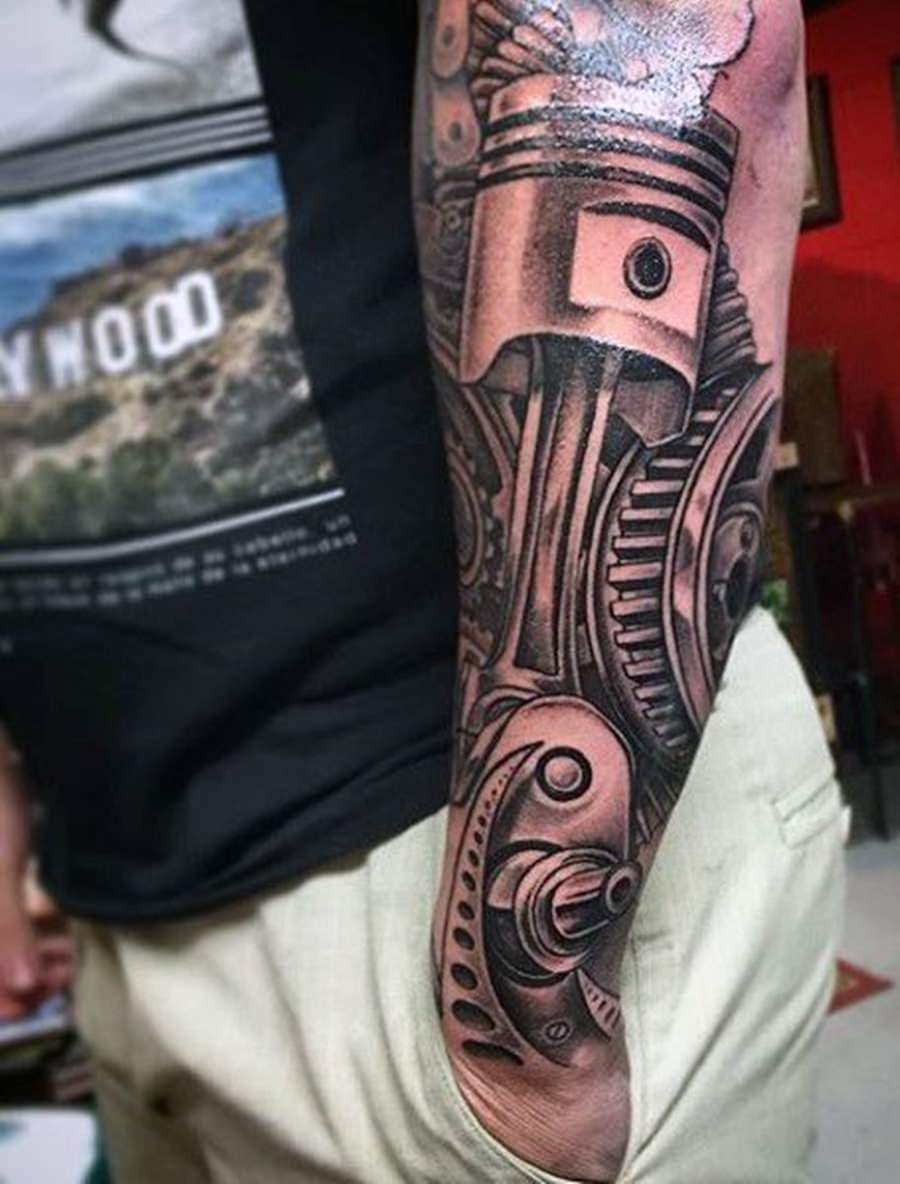 Peça de moto tatuada no braço