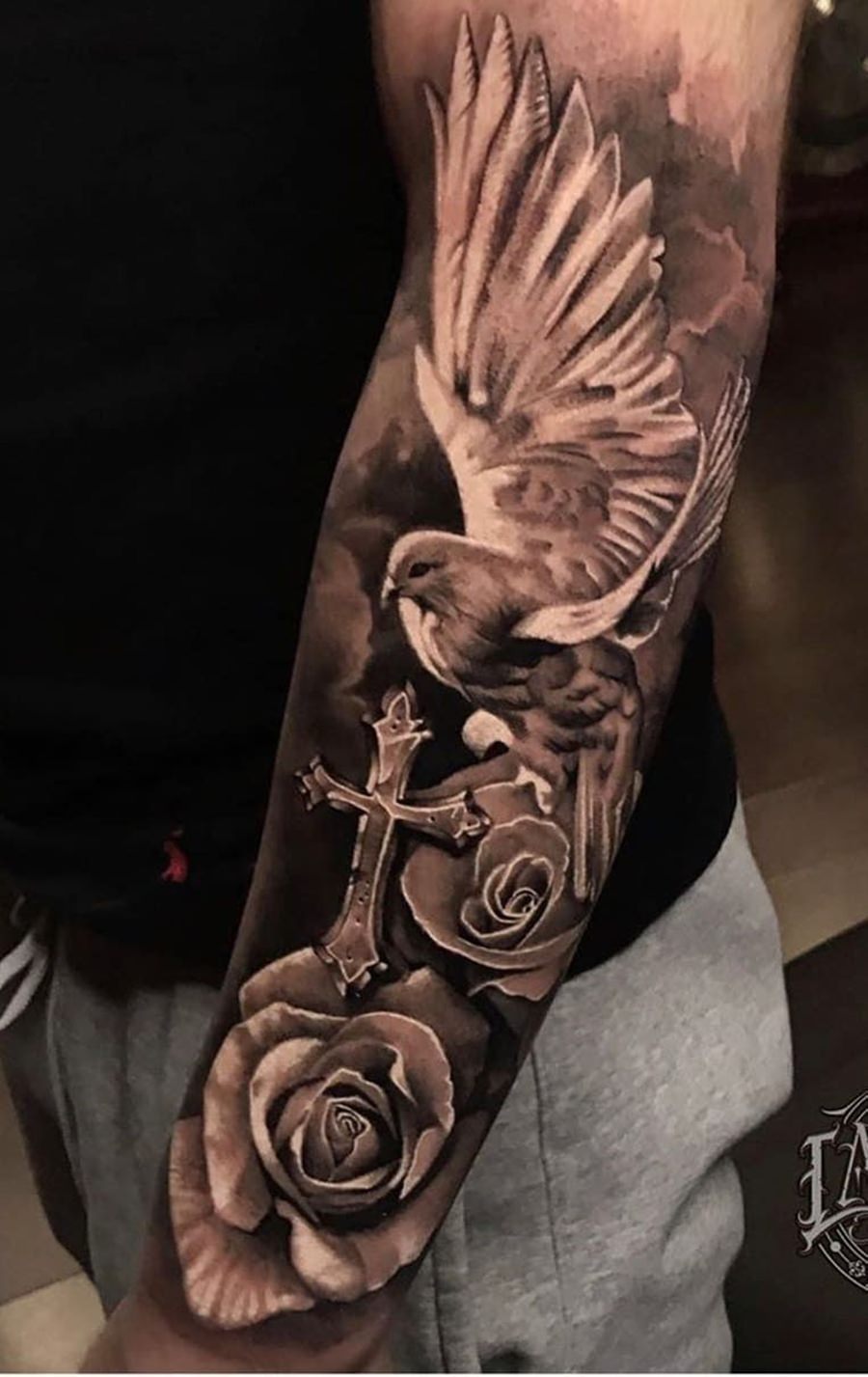 Bomba e cruz tatuada no braço